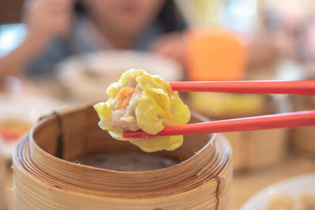 Chopsticks with tasty chinese steamed dumpling.の写真素材