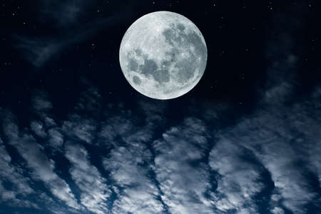 Full moon over clouds in the sky.