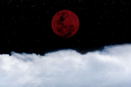 Lunar eclipse with white clouds in the dark night.の写真素材