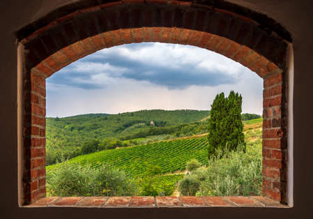 Landscape view of vineyards from the brick window, Tuscany, Italy.の写真素材