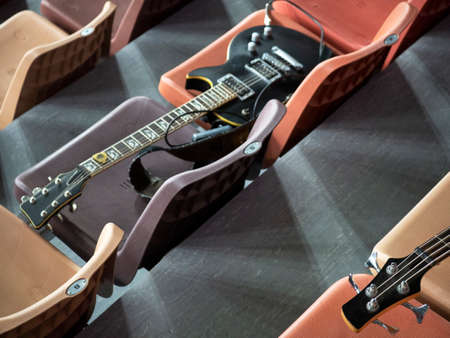 Two electric guitars lie on the seats in the concert hall. At intermission, rock guitarists laid their guitars parallel to each other on different rows in the auditoriumの写真素材