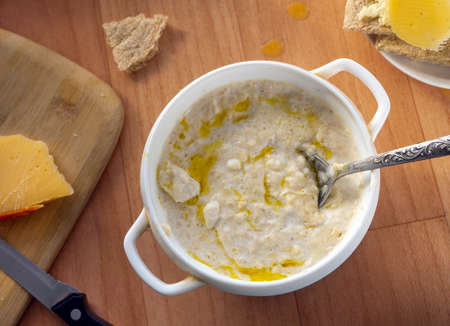 Porridge with vegetable oil for breakfast. On a plate are crispbread with cheese and butter. On a...