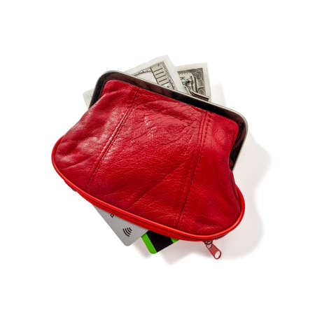 In a red leather wallet are dollar bills, bank credit and debit cards. Wallet isolated on a white...
