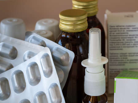 Medical background with medicines for various diseases in blisters, vials and other packaging.  Tinctures or liquid medicines in medical bottles, spray for nose, and pills close-up.の写真素材