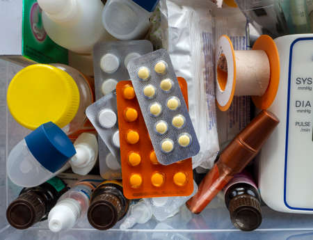 Medical supplies and first aid items are in the box. Tablets, dressings, inhalers, tonometer and other medicines close-up. Medical background.の写真素材
