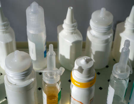 Cosmetic and medical products in plastic bottles close-up. Drops for the treatment of nose, eyes, ears and liquid cosmetics. Medical background for clinics, pharmacies, hospitals.の写真素材
