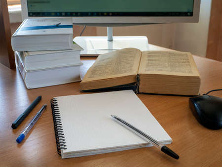Education and online learning concept. Books, a notebook, pens and a computer mouse are on the table...
