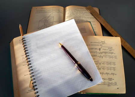 There is a pen on a blank page of the notebook. Notebook on top of open books. Place for your text. The concept of training, writing a scientific work, dissertation.の写真素材