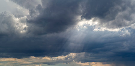 Heavenly landscape. The sun's rays break through the dark clouds. Sky background with clouds and sun...