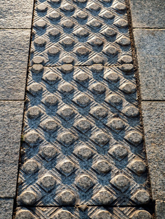 Tactile granite tiles with a grooved surface are removed in perspective. The lines of the cylinders are located diagonally. Stone texture of paving tactile tiles.の写真素材