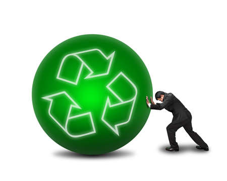 businessman rolling large green ball with recycle symbol on it isolated in white backgroundの写真素材