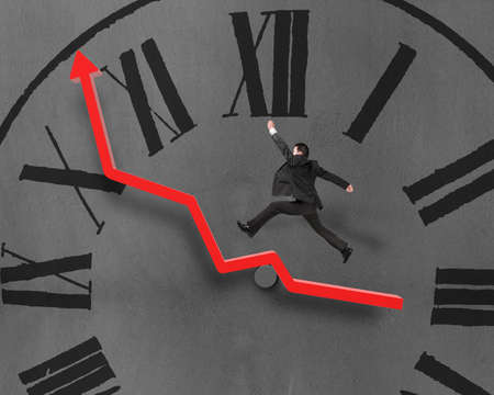 Man running and jumping on growth red arrow with chock face in concrete wall backgroundの写真素材