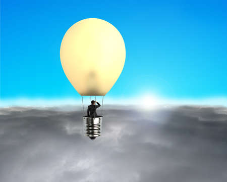 Man taking glowing lamp balloon flying over clouds with sun and blue skyの写真素材