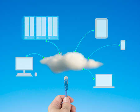 Hand hold Network cable connect to cloud computing service in blue skyの写真素材