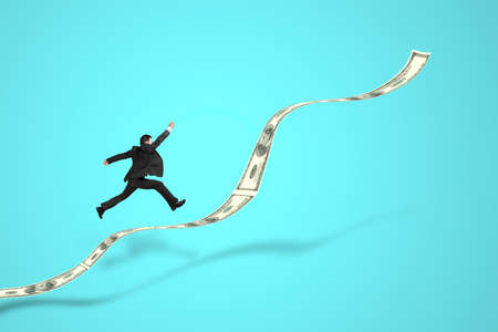 businessman jumping on growth money trend in greenの写真素材