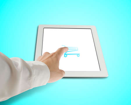 Hand touching shopping cart icon on tabletの写真素材