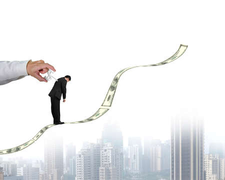 Hand winding money winder on businessman's back with growing money trendの写真素材