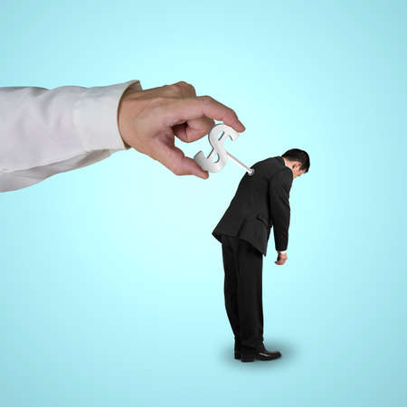 Hand winding winder on businessman's back in blue backgroundの写真素材