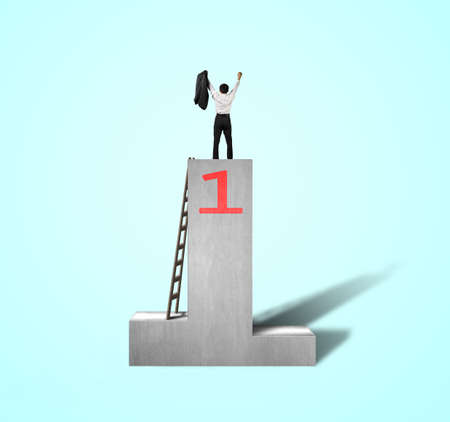 Cheered businessman standing on podium with wooden ladder isolated in greenの写真素材