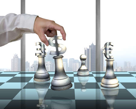 Hand holding money symbol others on table playing chess with city viewの写真素材