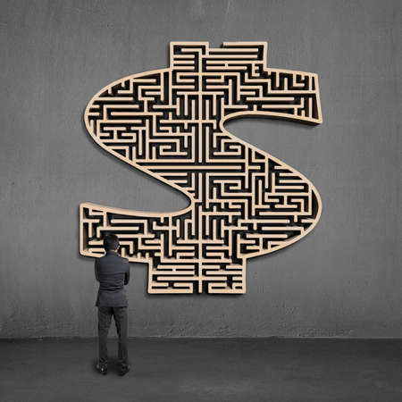 businessman facing wooden mooney shape maze on concrete wallの写真素材