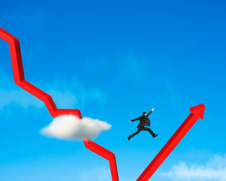 Businessman jumping over gowing down red arrow blue skyの写真素材