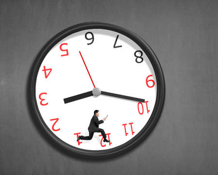 Running inside clock on concrete wallの写真素材