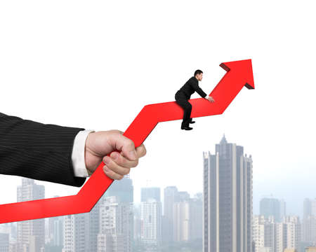 Holding red arrow with hand sitting and city view backgroundの写真素材