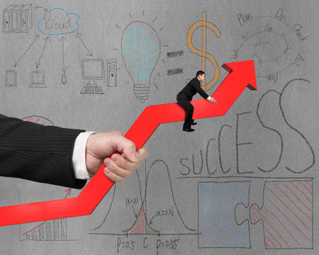 Riding on red arrow with hand holding and business doodles on wallの写真素材