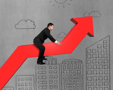 Businessman on red arrow with building doodles on concrete wallの写真素材