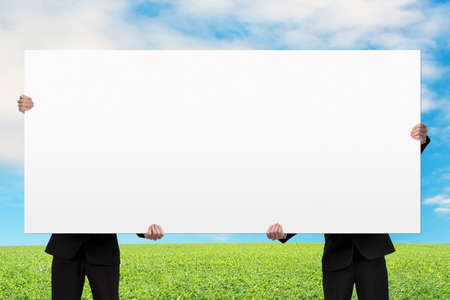 Two men lifting blank board with nature の写真素材