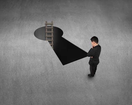 Top view for businessman, key shape hole and wooden ladderの写真素材