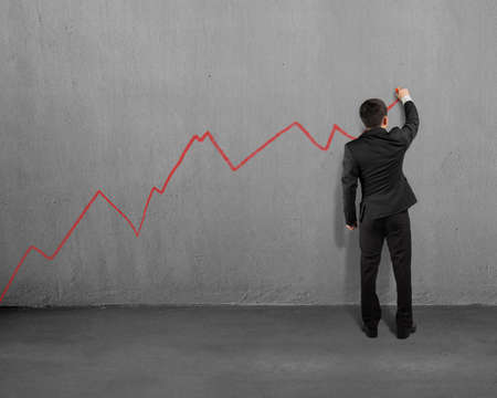 Drawing growing red trend on concrete wallの写真素材