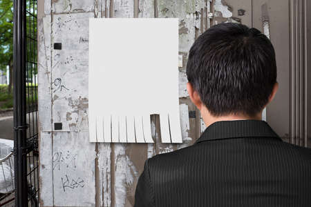 man look at blank paper on noticeboard with street