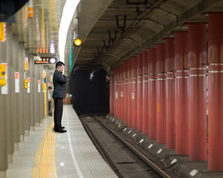 businessman thinking and standing on the platform wait for trainの写真素材