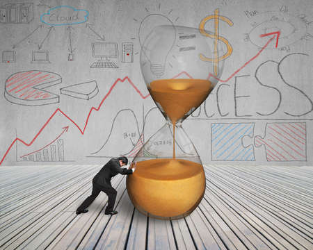 businessman push inclined hourglass on wooden floor with doodles wall
