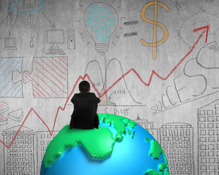 businessman sitting on 3d map globe watching doodle concrete wallの写真素材