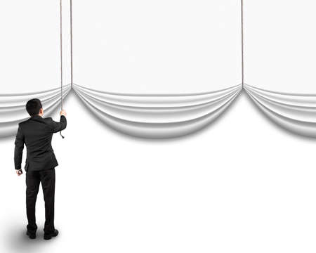 businessman pulling open blank curtain with empty behind isolated on white backgroundの写真素材
