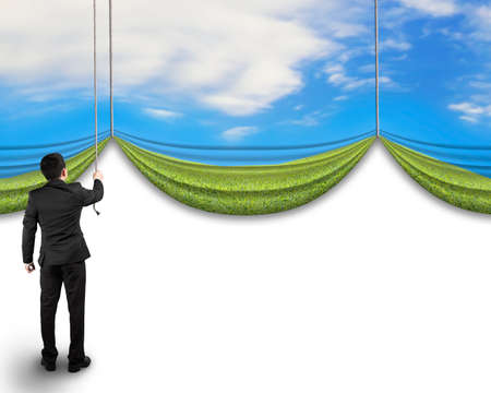 businessman pulling open natural sky meadow curtain revealed blank white backgroundの写真素材