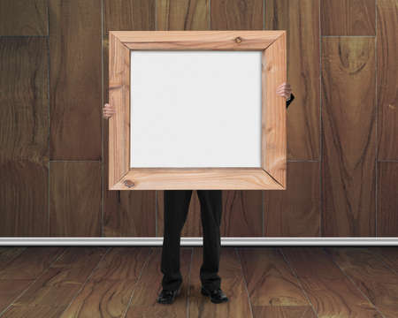 businessman holding blank whiteboard with wood frame on wooden room background