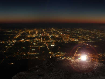 Lit lamp on rock mountain with city night view backgroundの写真素材