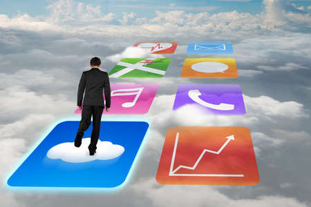 Rear view businessman surfing on shiny cloud app icons with cloudscape background