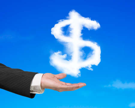 Hand holding white dollar sign shape cloud with blue sky backgroundの写真素材