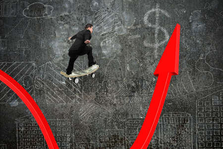 Businessman skateboarding on red growing arrow graph with doodles wall backgroundの写真素材