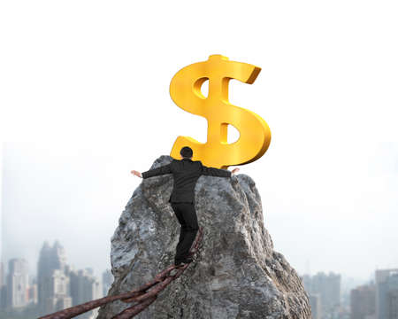Businessman walking and balancing on old iron chain toward golden dollar sign of mountain peak with cityscape backgroundの写真素材