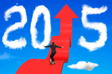 Skateboarding businessman balancing on red arrow upward path with 2015 shape clouds and blue sky backgroundの写真素材