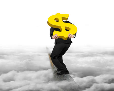 Businessman carrying big 3D gold dollar sign balancing on concrete ridge with gray cloudy sky backgroundの写真素材