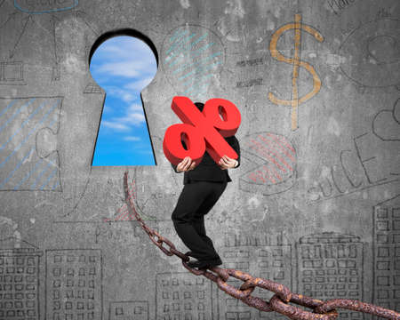 Man carrying 3D red percentage sign walking on old iron chain toward keyhole door, with sky clouds view and business concept doodles wall backgroundの写真素材
