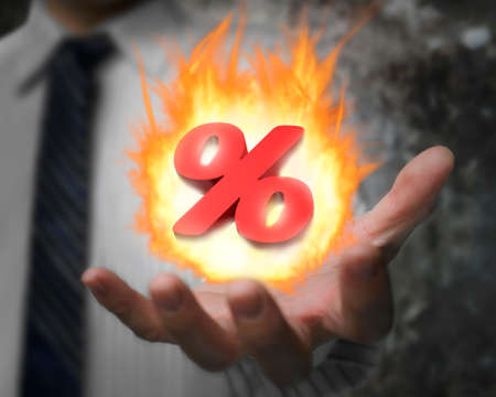 Business man hand showing 3D red percentage sign with burning fire ballの写真素材