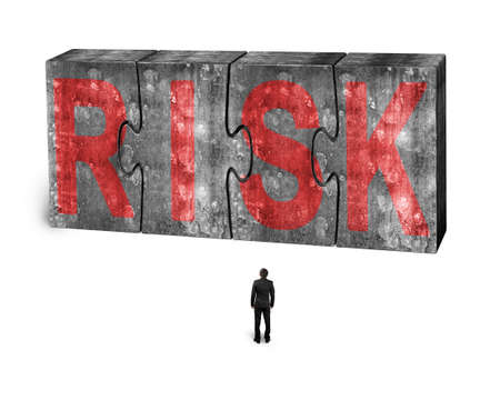 Man facing red risk word on four huge concrete puzzles connected together, isolated on white...